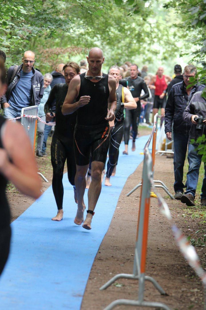 Een groep mensen rent op een blauw pad.