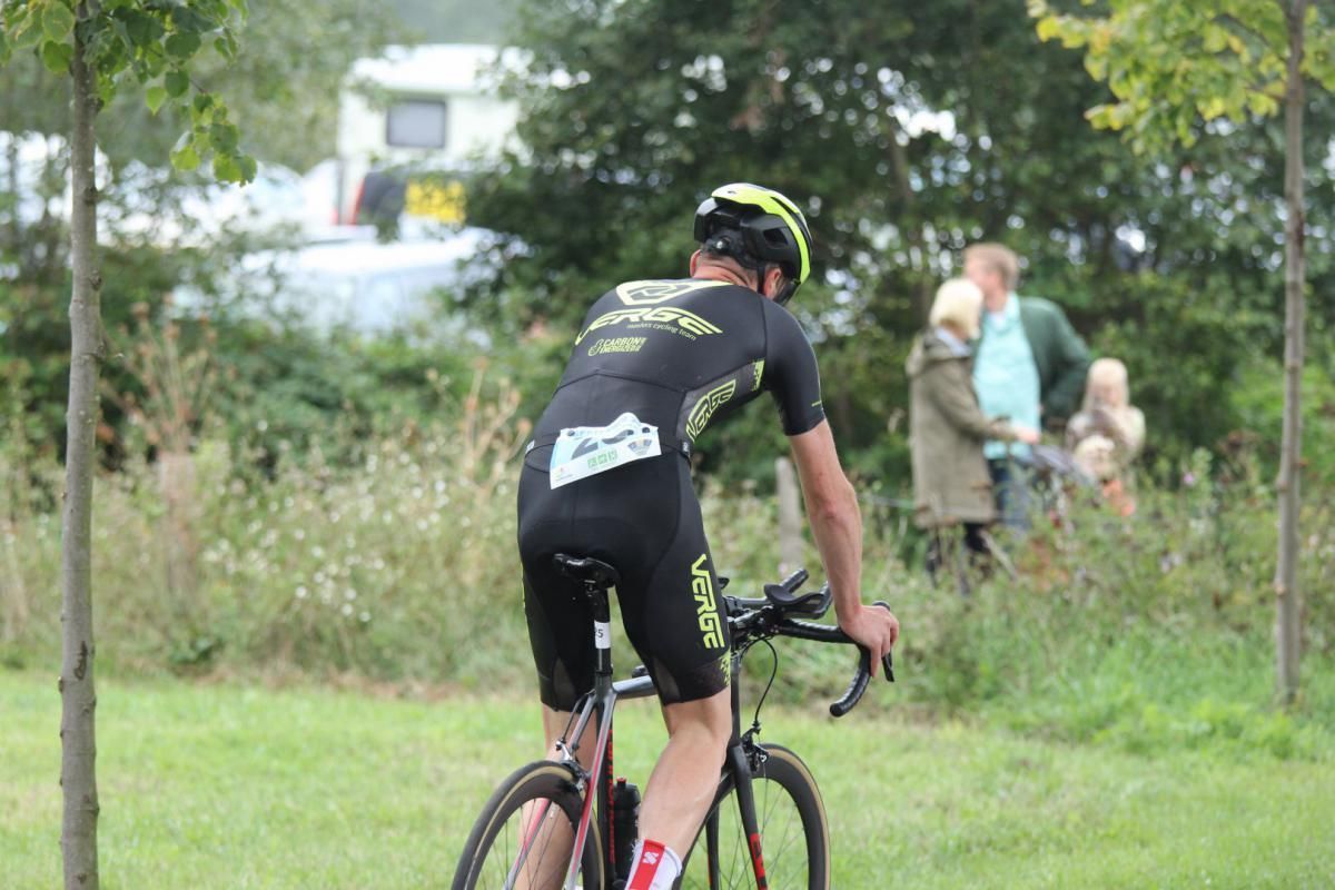 Een man fietst op een grasveld.