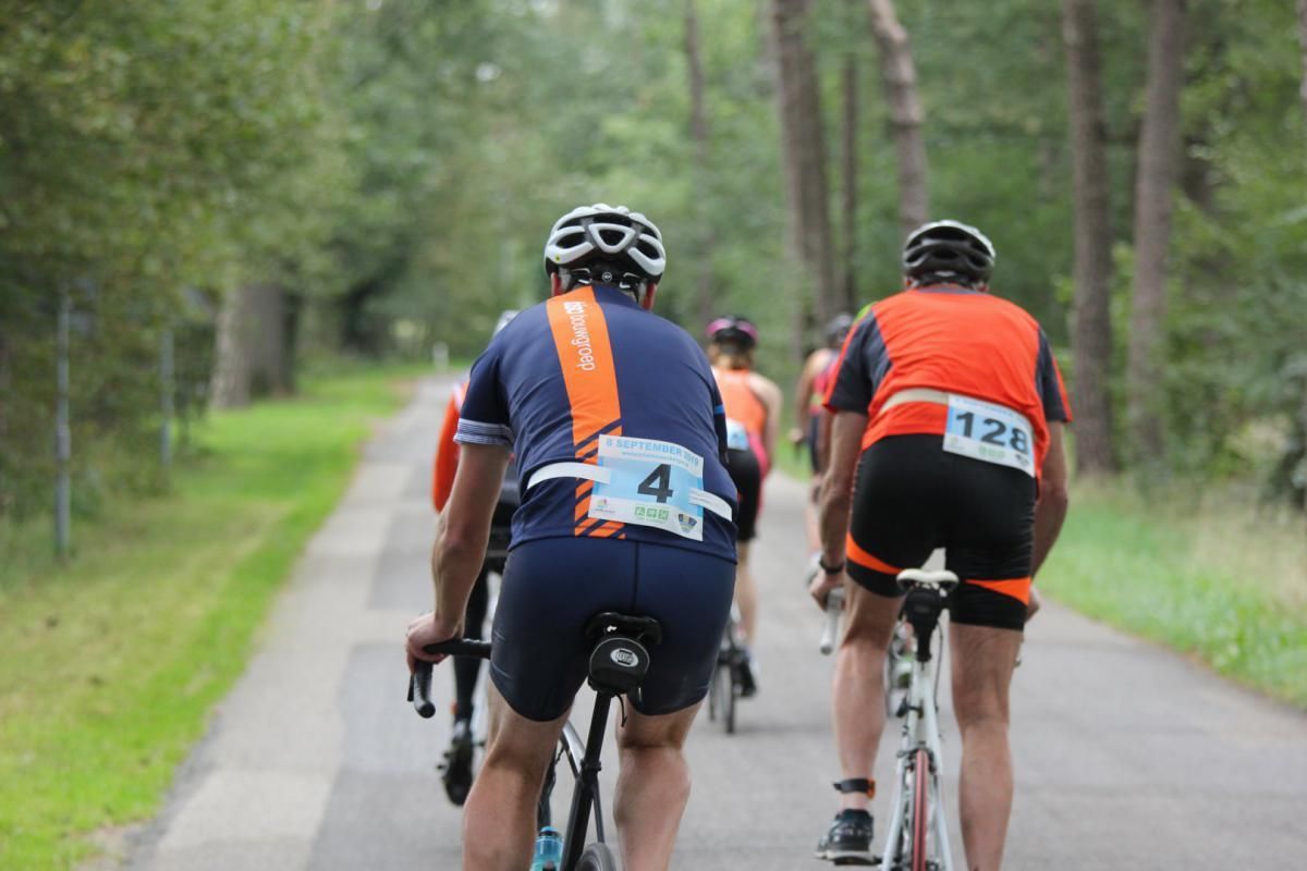 Een groep mensen fietst over een weg.