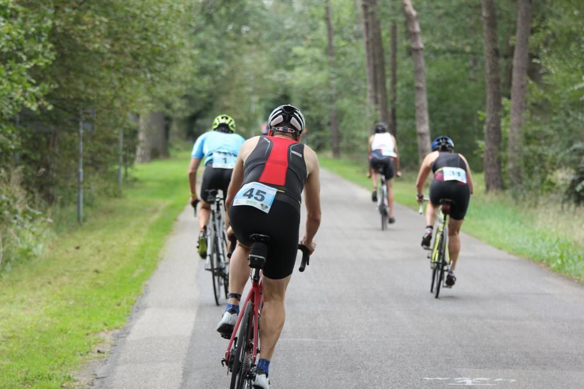 Een groep mensen fietst over een weg.