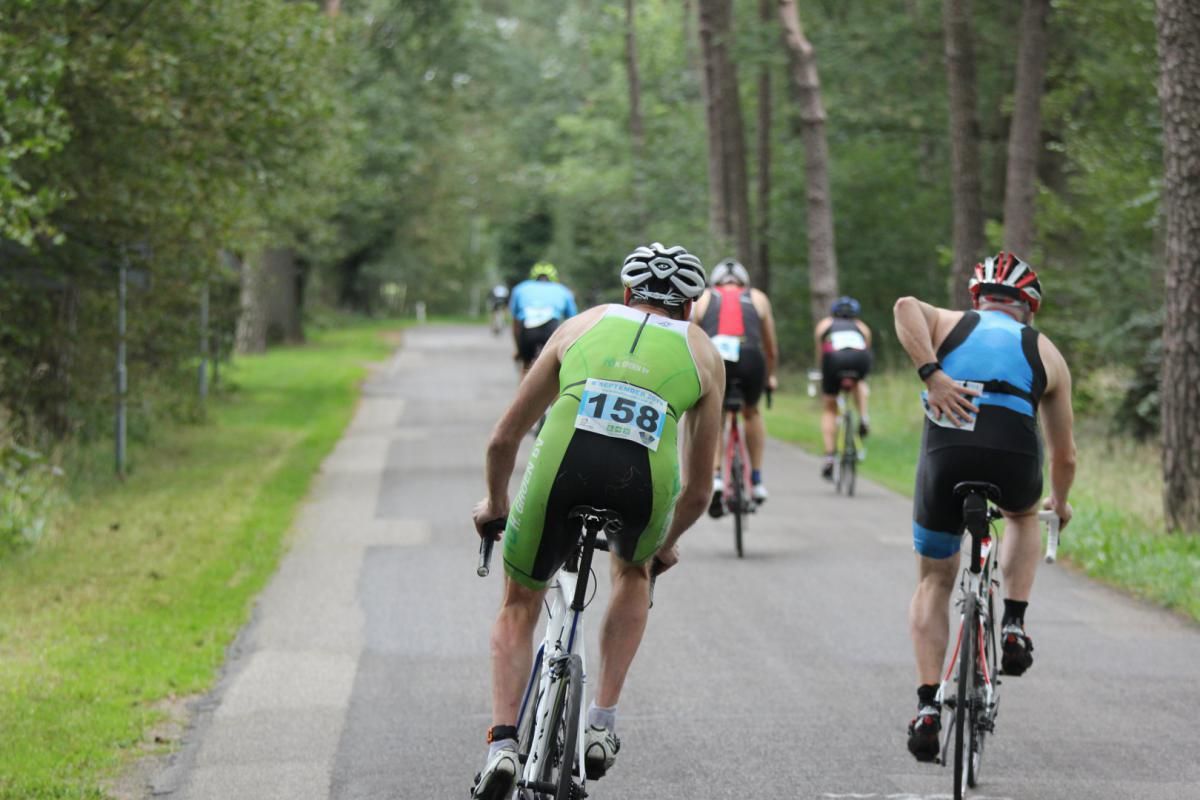 Een groep mensen fietst over een weg.