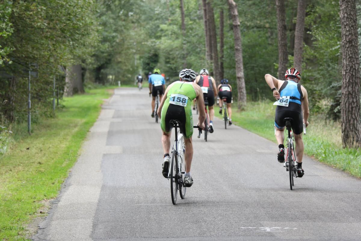 Een groep mensen fietst over een weg.