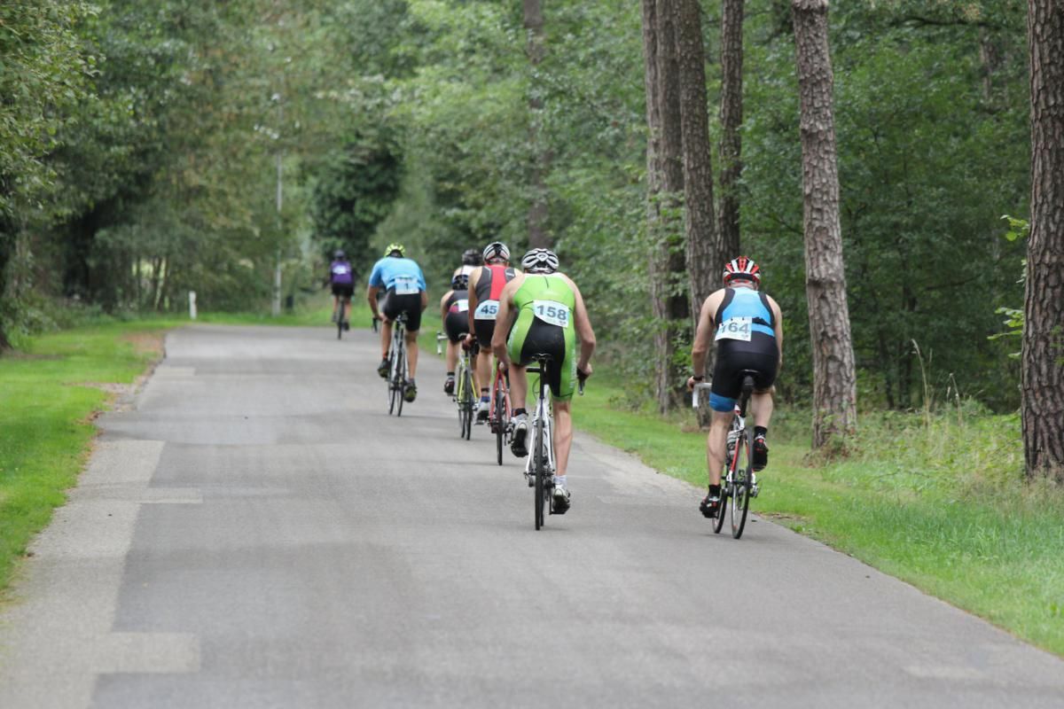 Een groep mensen fietst over een weg.