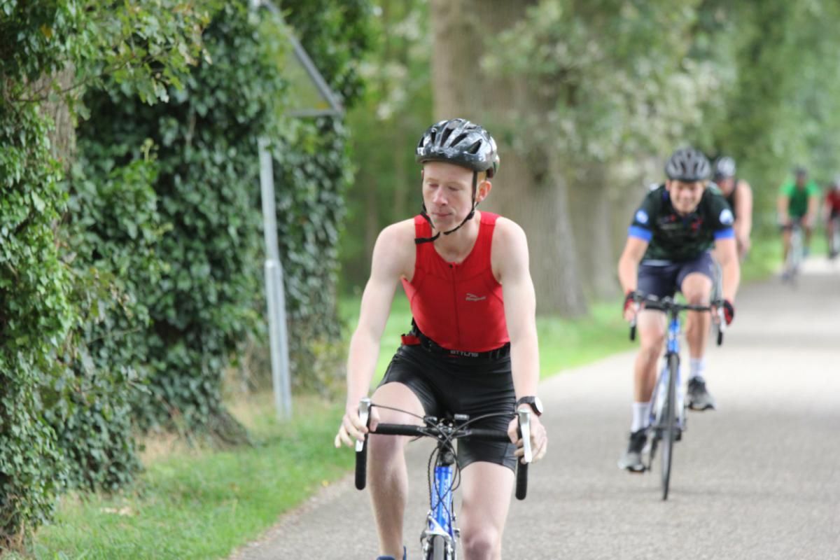 Een groep mensen fietst over een weg.