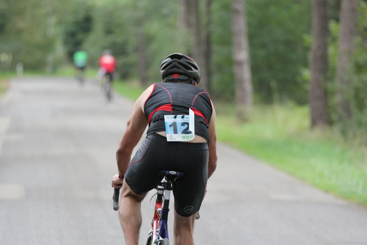 Een man fietst over de weg met het nummer 12 op zijn rug.