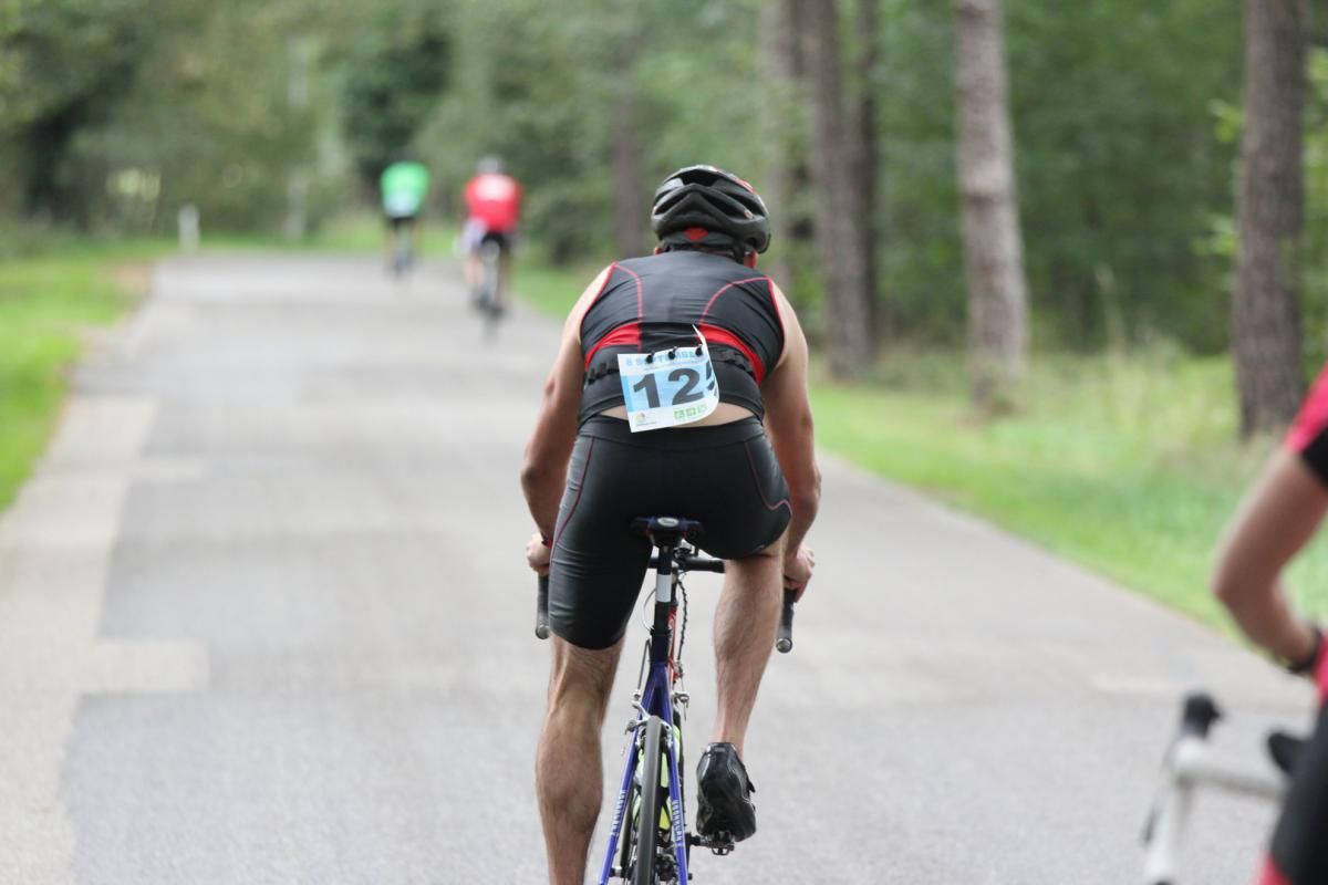 Een man fietst over de weg met het nummer 12 op zijn rug.
