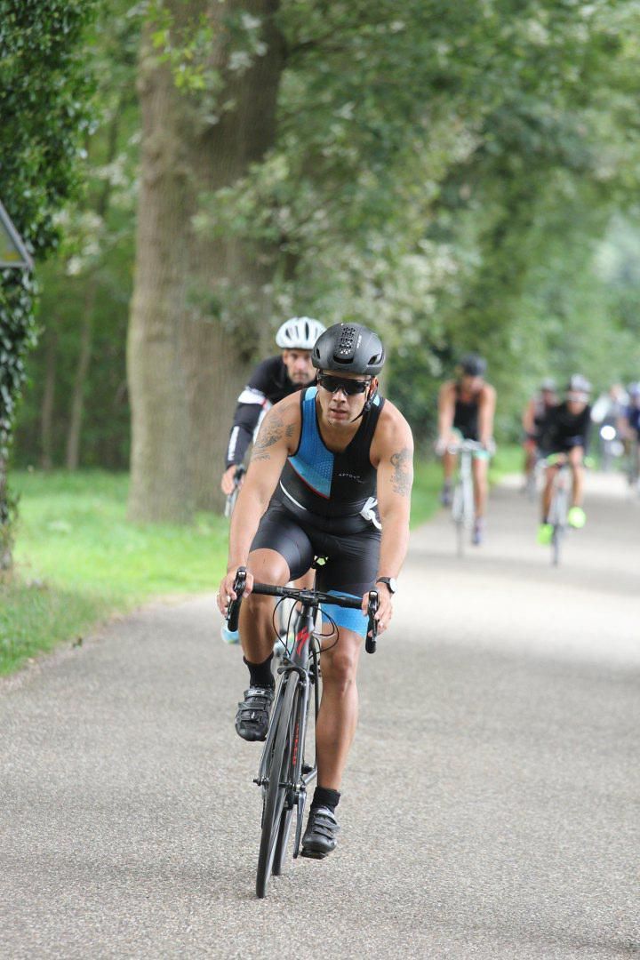Een groep mensen fietst over een weg.