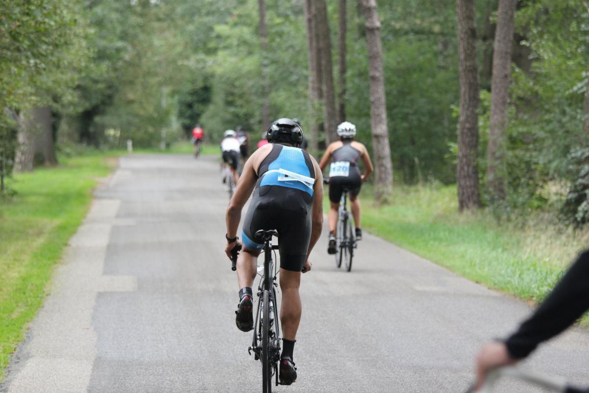 Een groep mensen fietst over een weg.