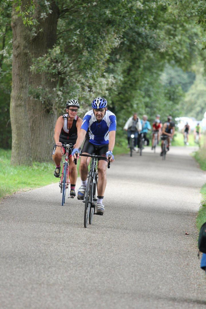Een groep mensen fietst over een pad.