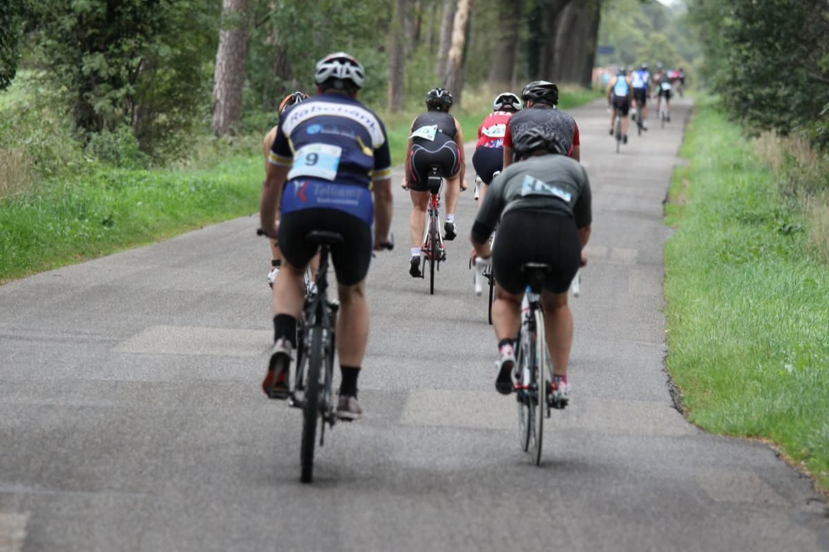 Een groep mensen fietst over een weg.
