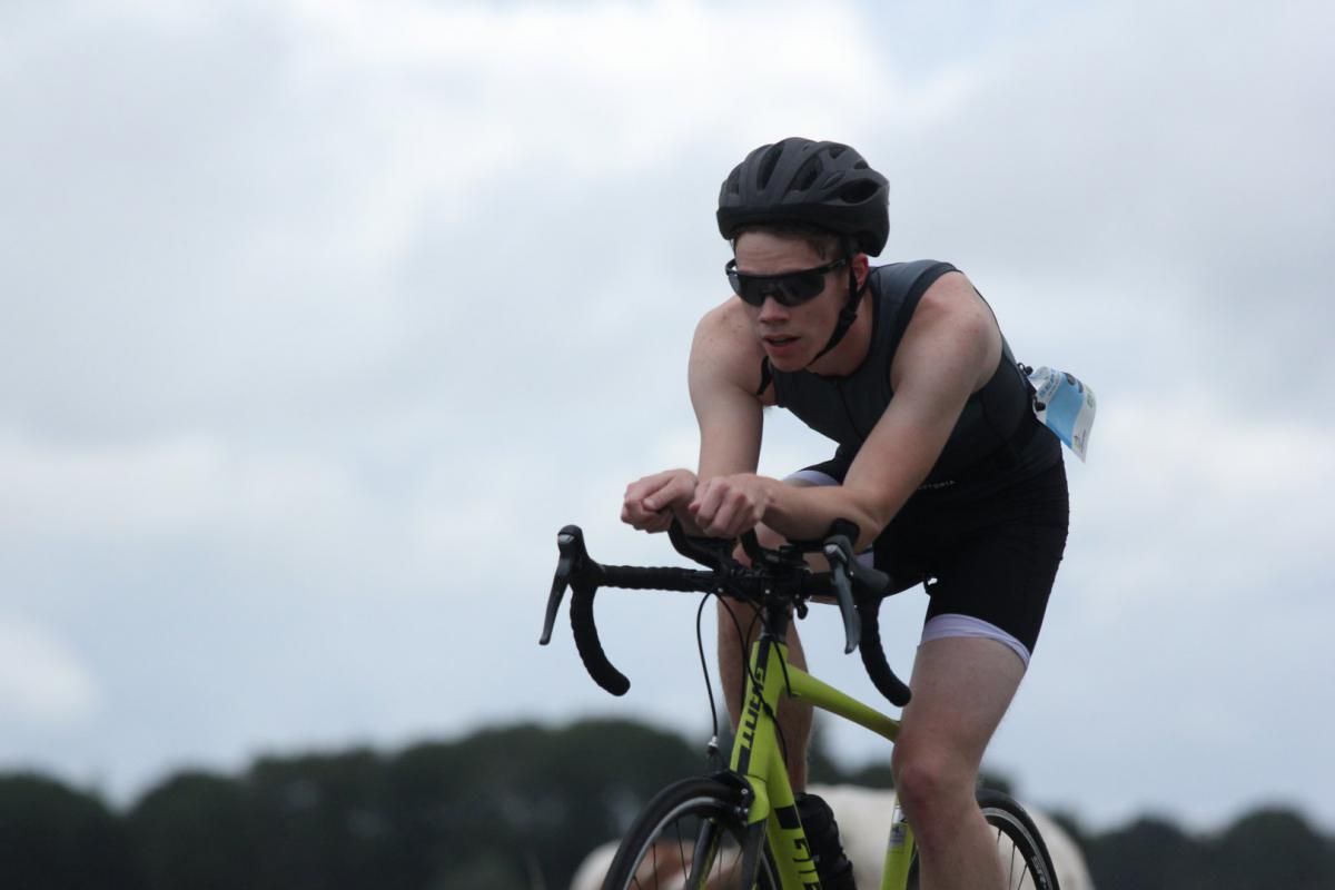 Een man met een helm en een zonnebril rijdt op een fiets