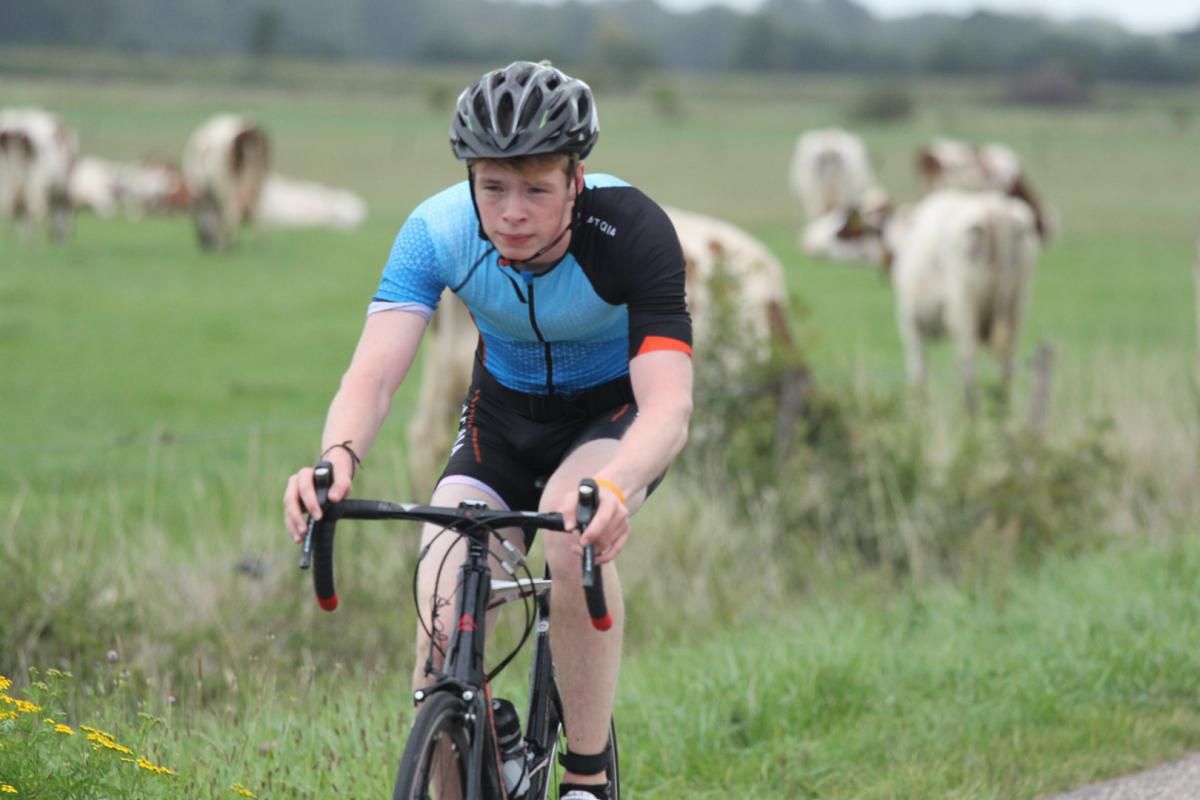 Een jonge jongen fietst op een landweg.