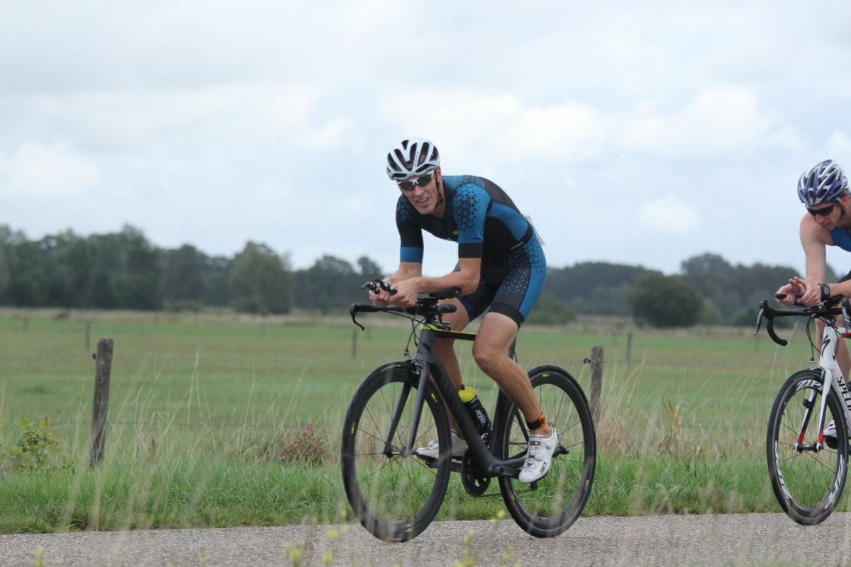 Twee mannen fietsen over een onverharde weg.