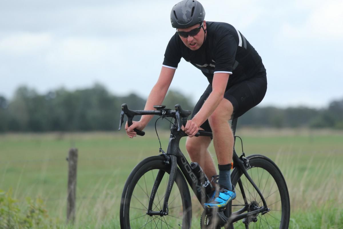 Een man fietst op een grasveld.