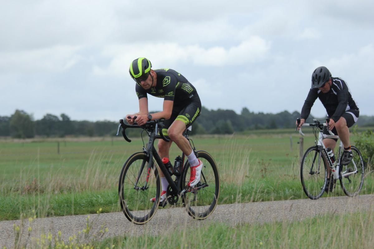Twee mannen fietsen over een onverharde weg.