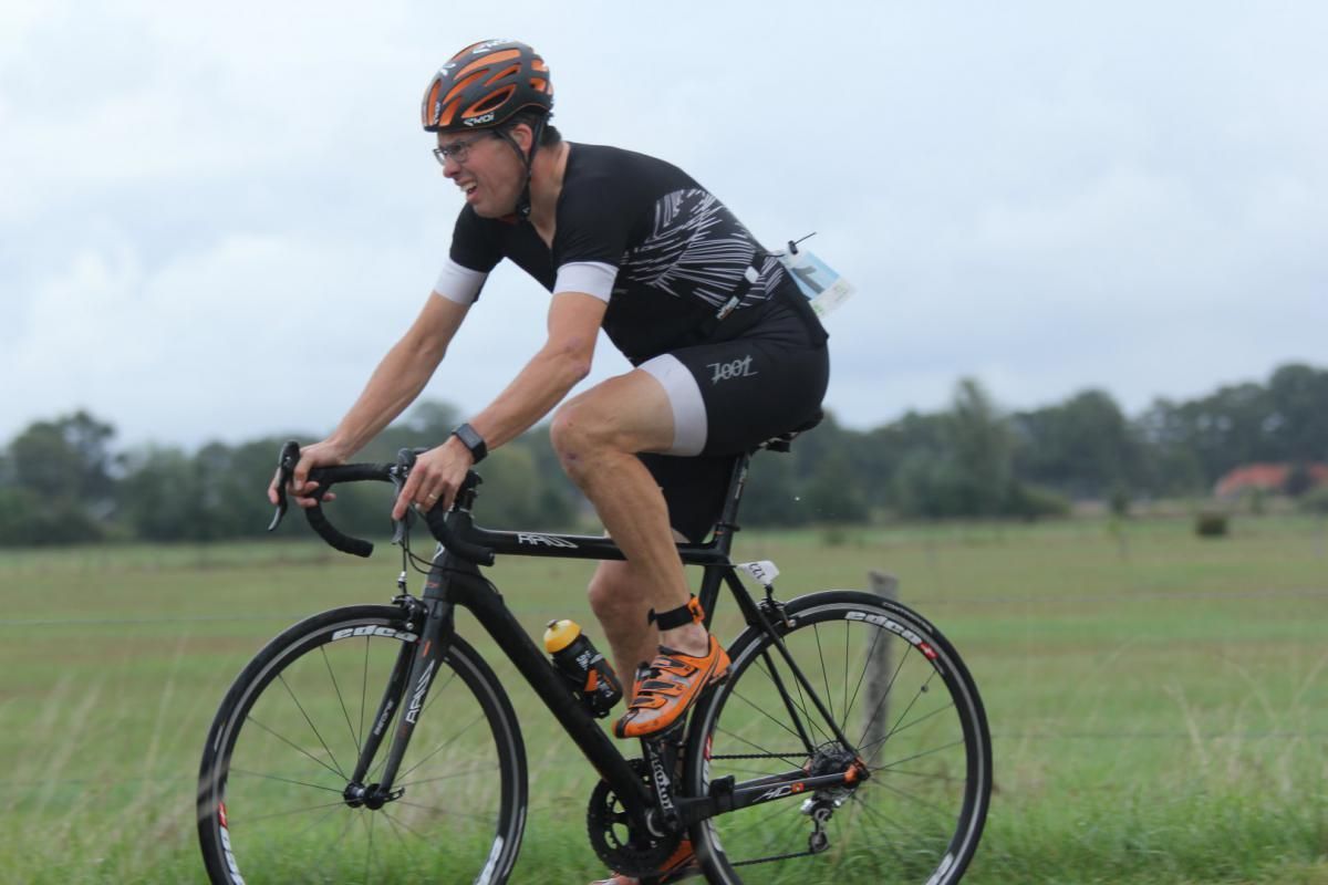 Een man fietst op een grasveld