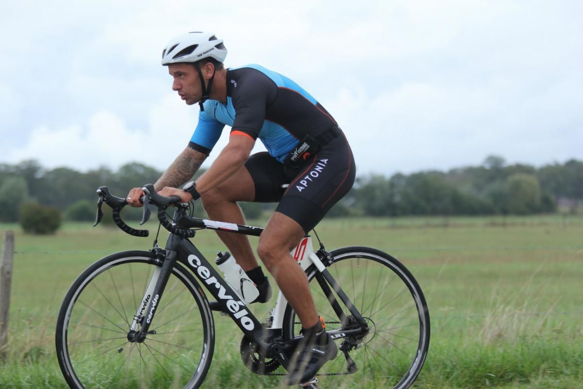 Een man rijdt op een cervelo-fiets in een veld