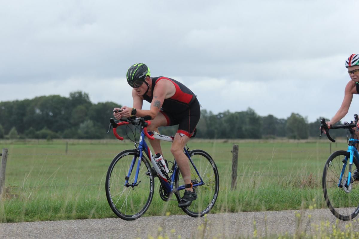 Twee mannen fietsen over een onverharde weg.