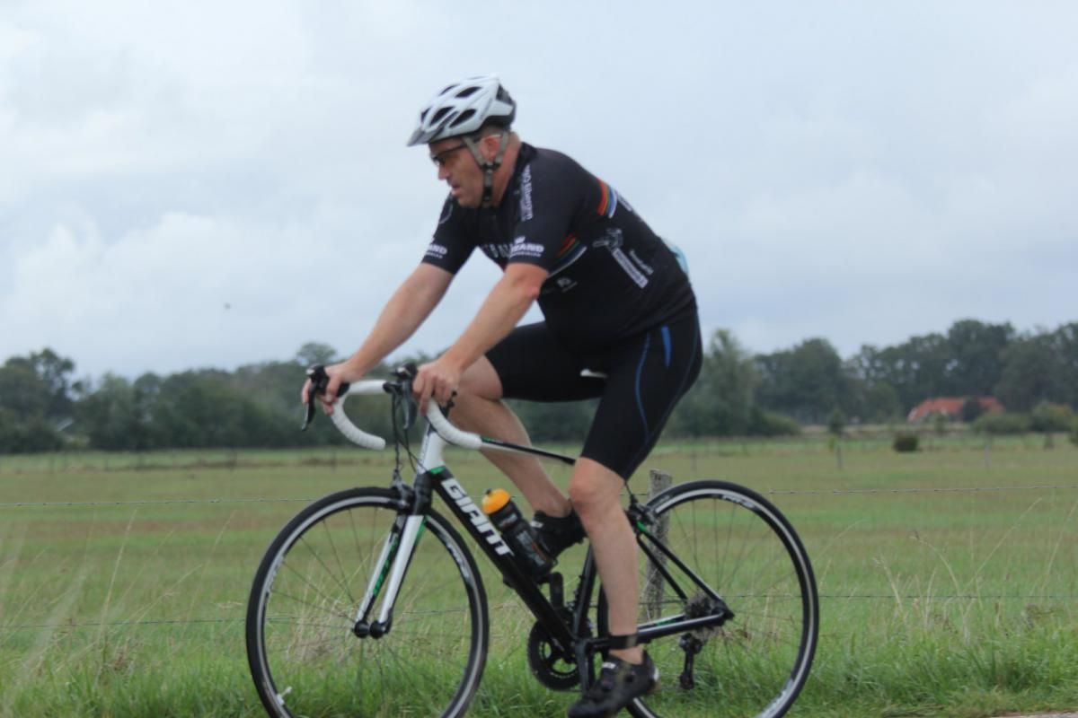 Een man met een helm rijdt op een gigantische fiets