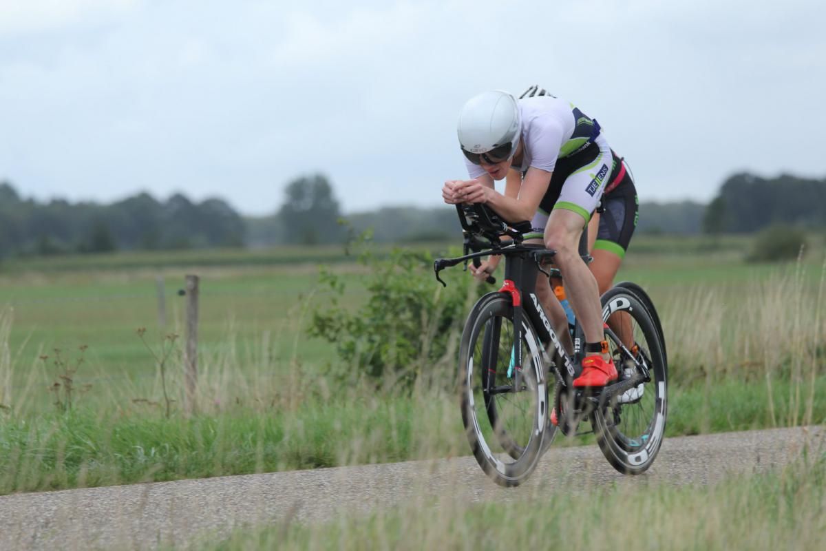 Een man fietst over een onverharde weg.