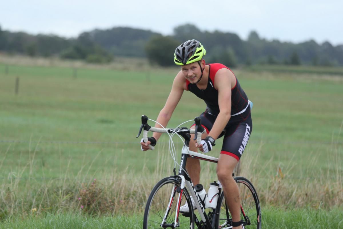 Een man fietst op een grasveld.