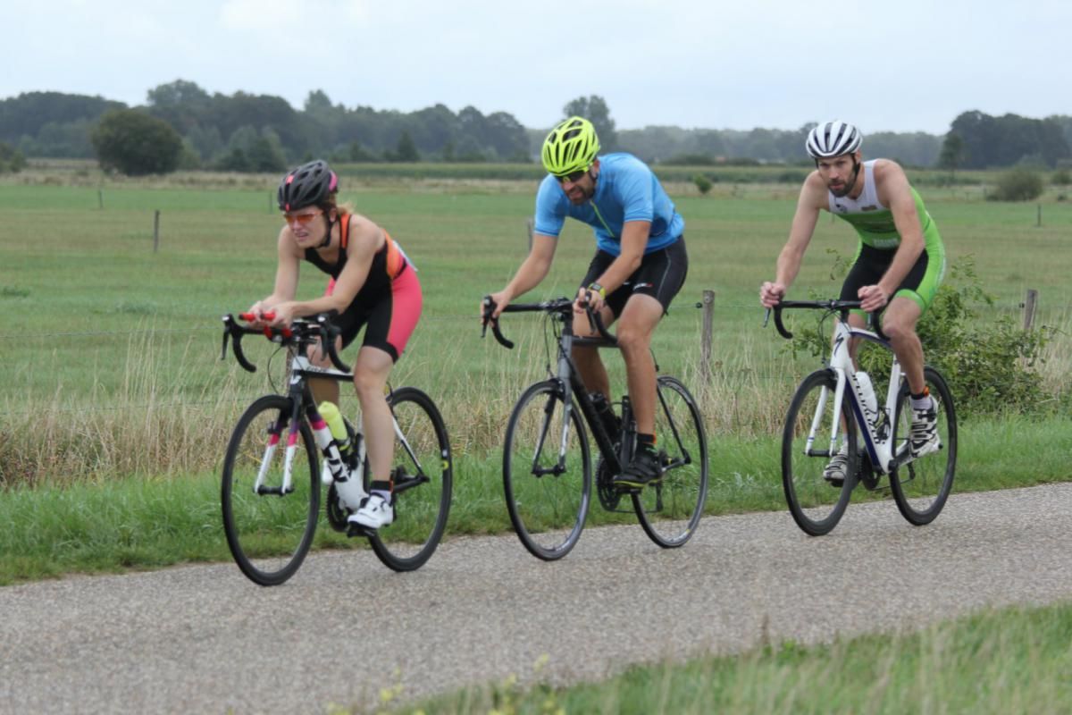 Drie mensen fietsen over de weg.