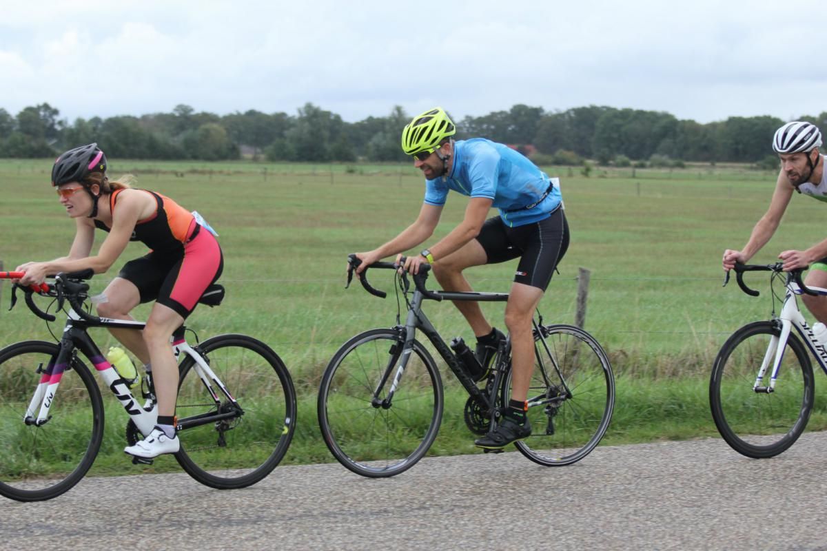 Een groep mensen fietst over een weg.