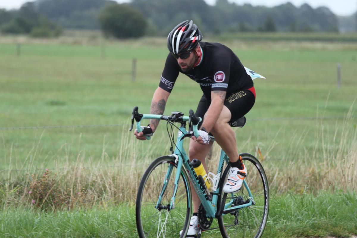 Een man fietst op een grasveld