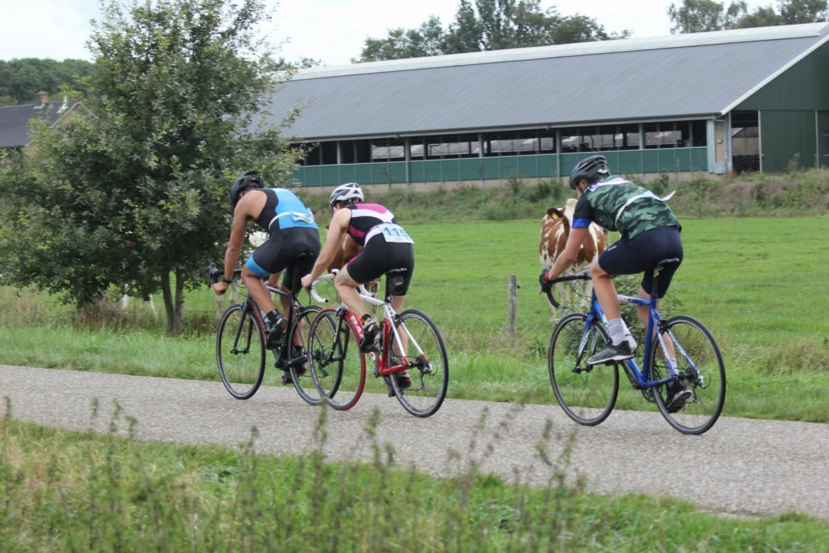 Een groep mensen fietst over een pad.