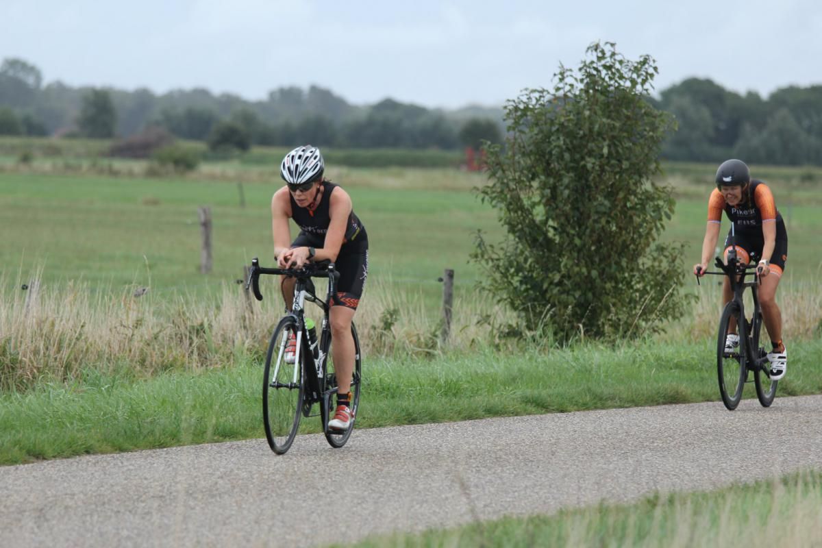Twee mensen fietsen over een weg.