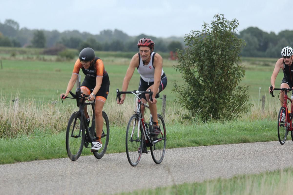 Een groep mensen fietst over een weg.