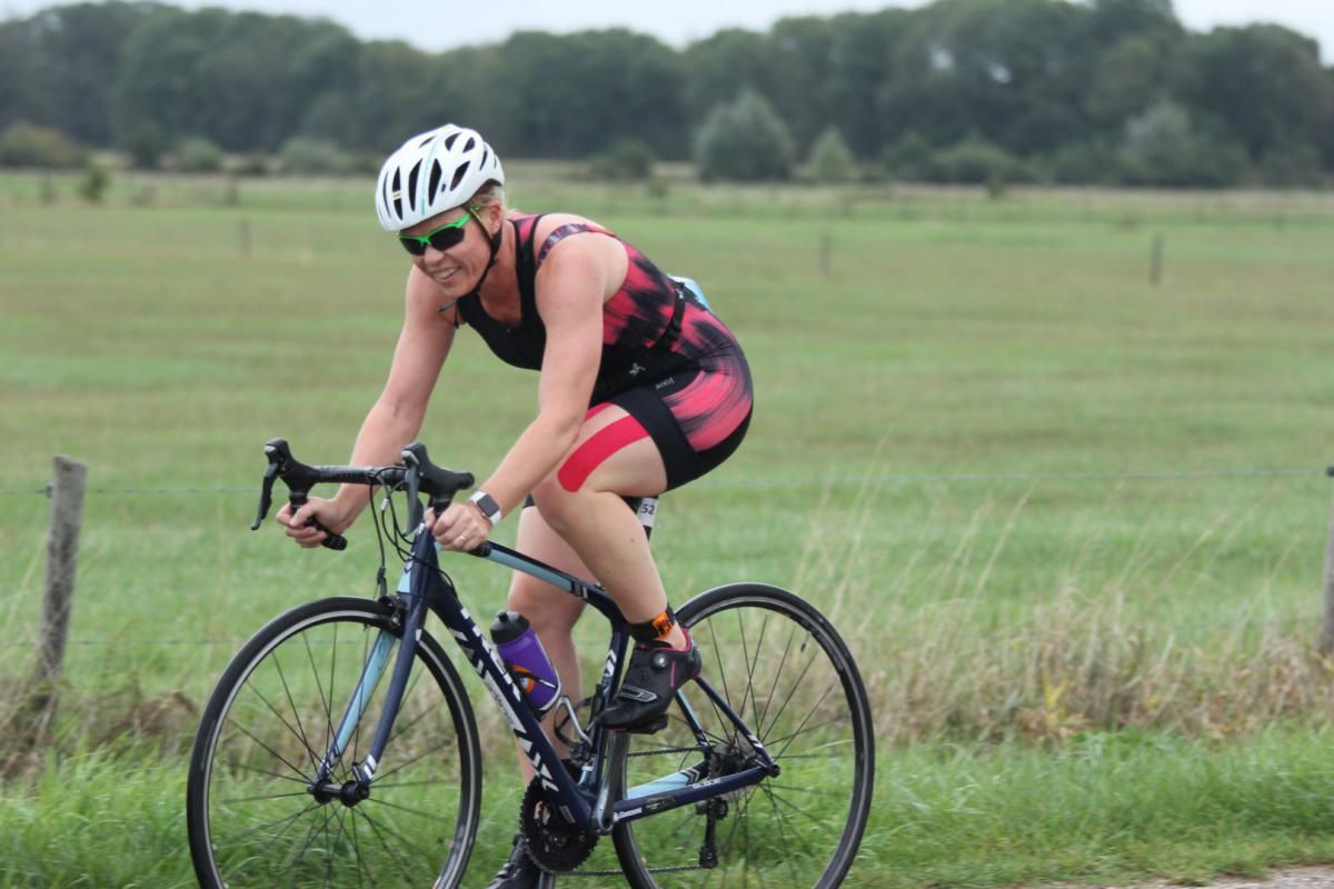 Een vrouw fietst op een grasveld.