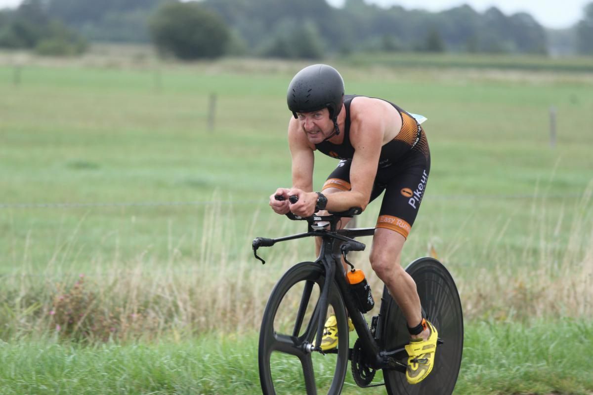 Een man fietst op een grasveld.
