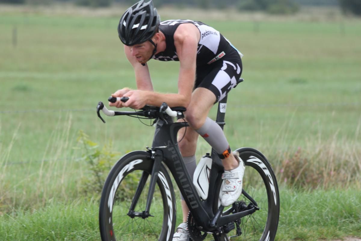 Een man fietst op een grasveld.