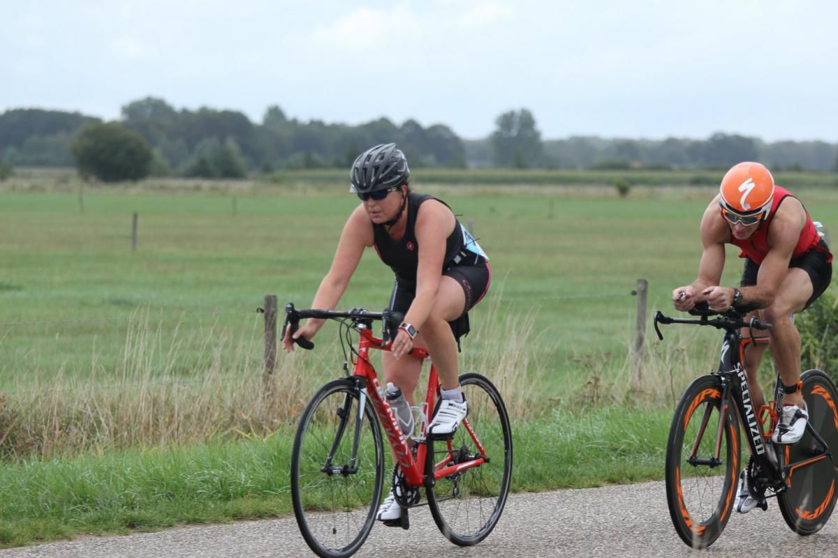 Twee mensen fietsen over een onverharde weg.