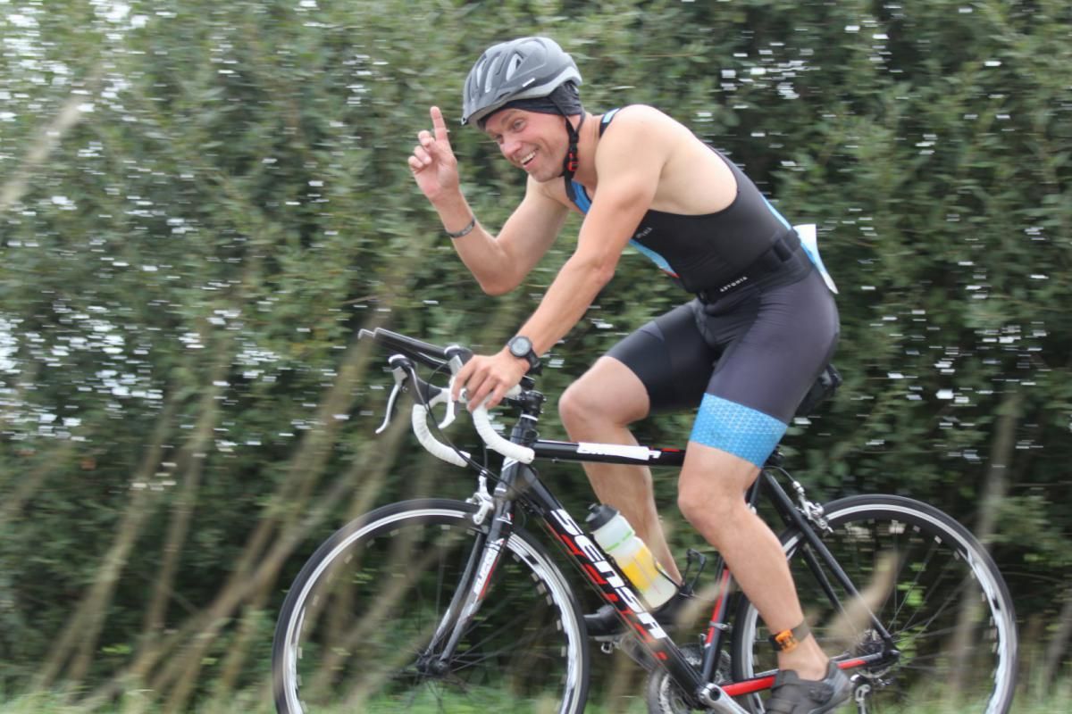 Een man met een helm rijdt op een fiets