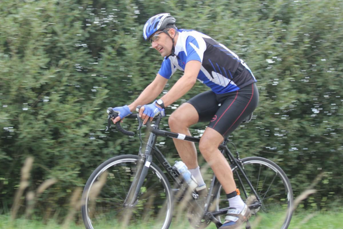 Een man met een helm rijdt op een fiets