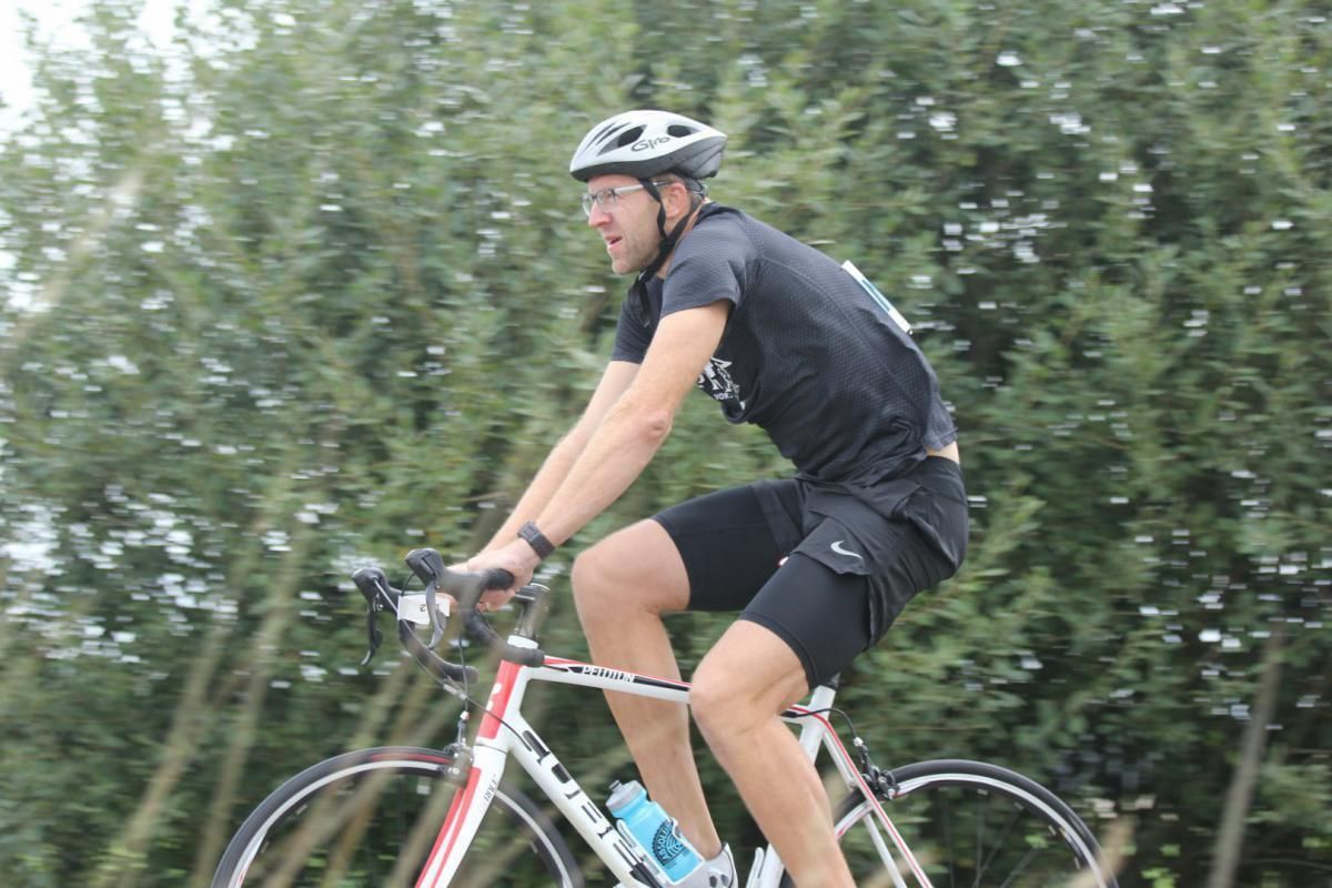 Een man met een helm rijdt op een fiets