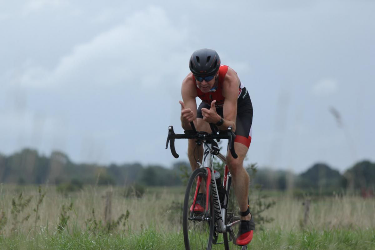 Een man fietst op een grasveld.