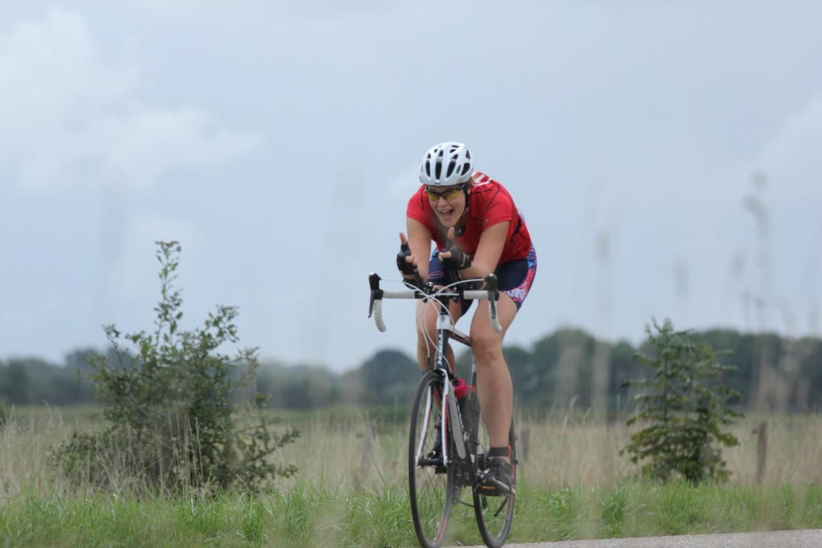 Een vrouw fietst over een weg.
