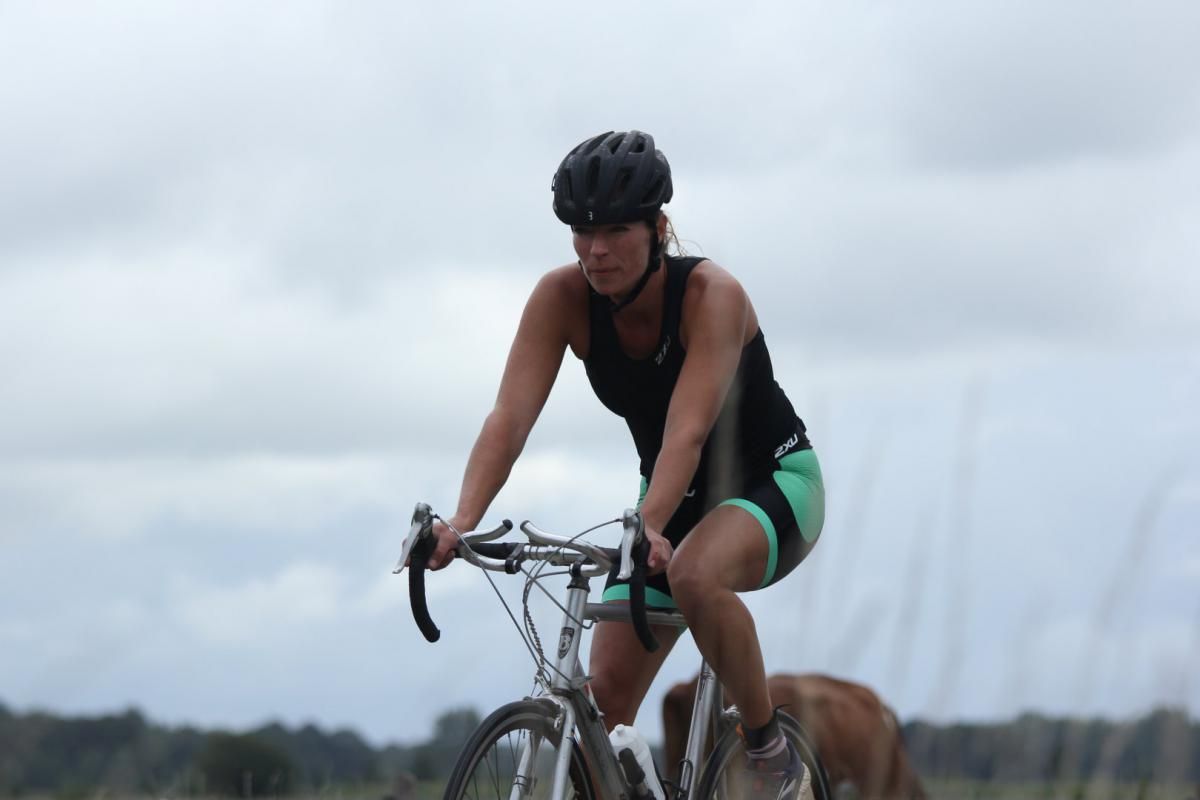 Een vrouw fietst naast een hond