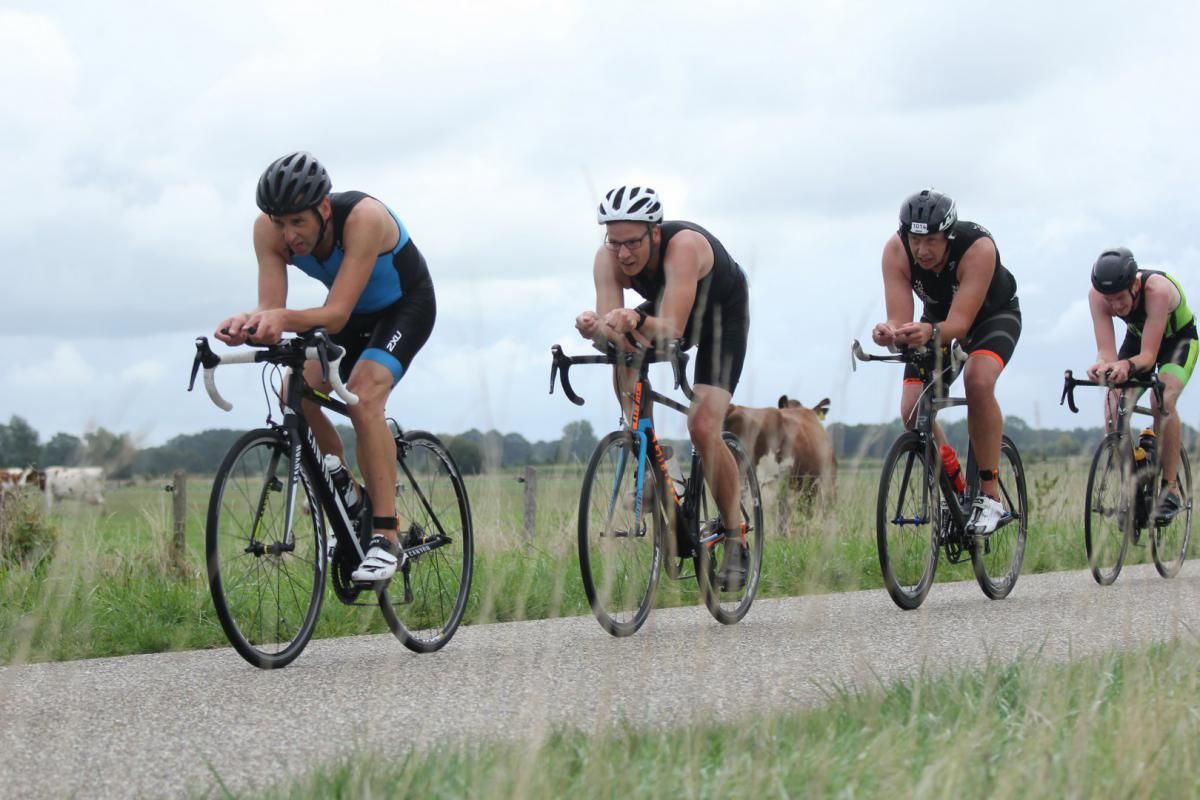 Een groep mensen fietst over een weg
