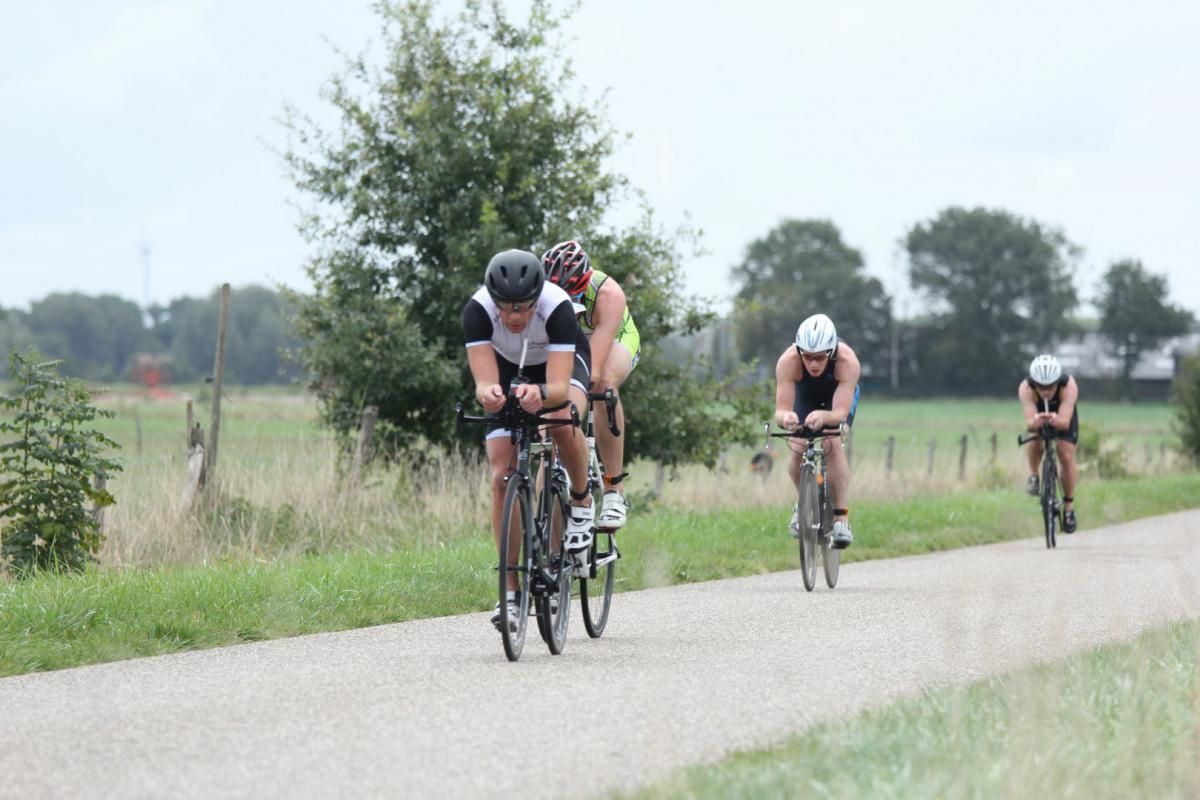 Een groep mensen fietst over een weg.