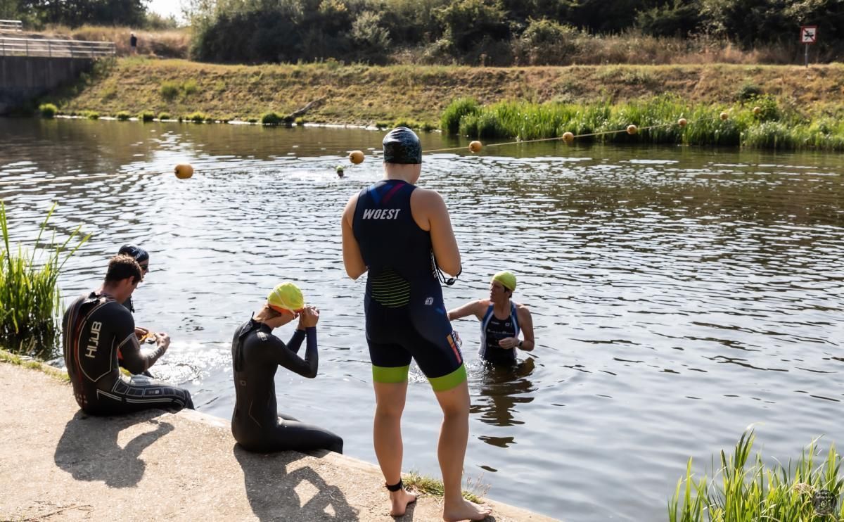 Een groep mensen staat aan de oever van een rivier.