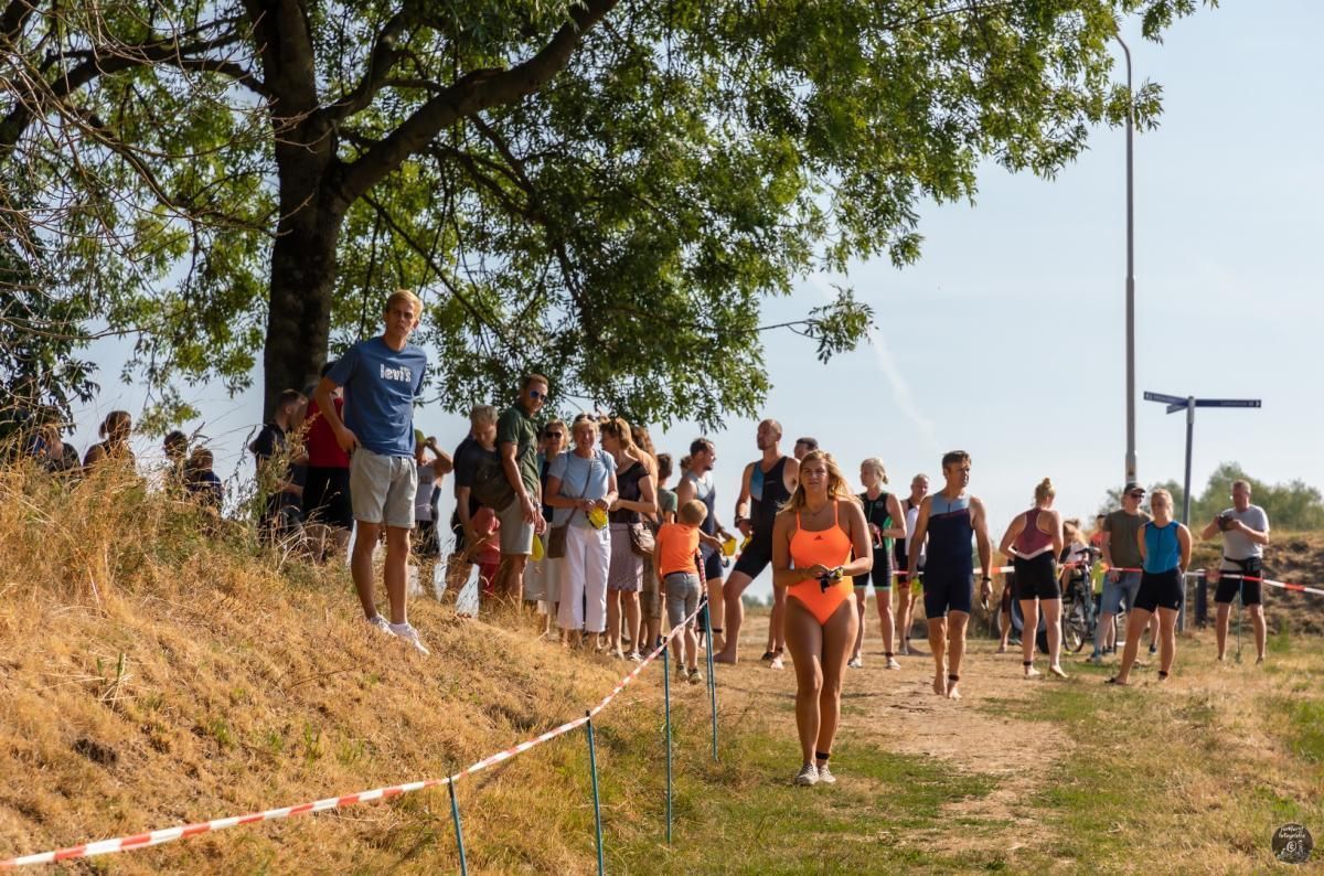 Een groep mensen loopt over een onverharde weg.
