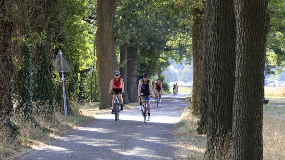 Een groep mensen fietst over een pad.