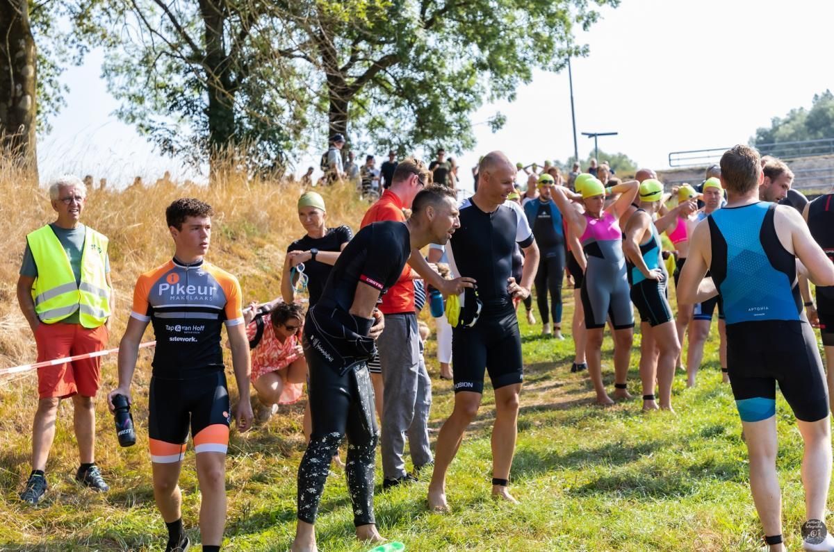 Een groep mensen staat in een grasveld.