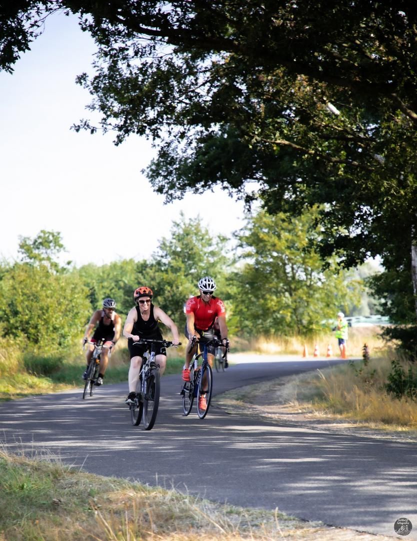Een groep mensen fietst over een weg.