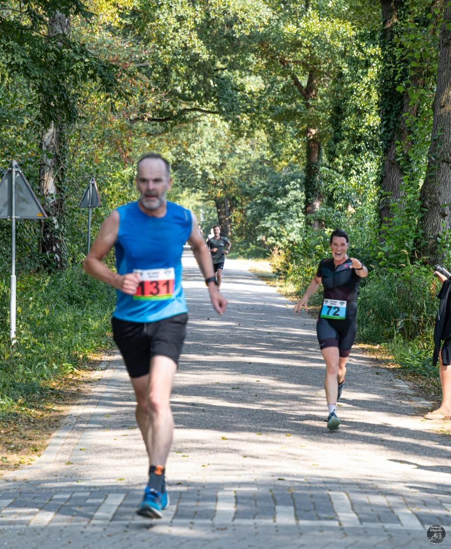 Een man en een vrouw rennen over de weg.