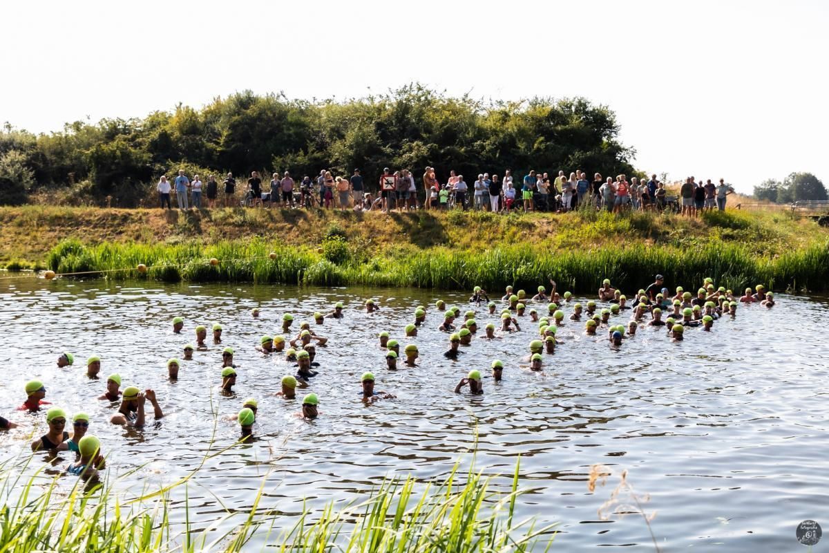 Een groep mensen staat op een heuvel met uitzicht op een watermassa.